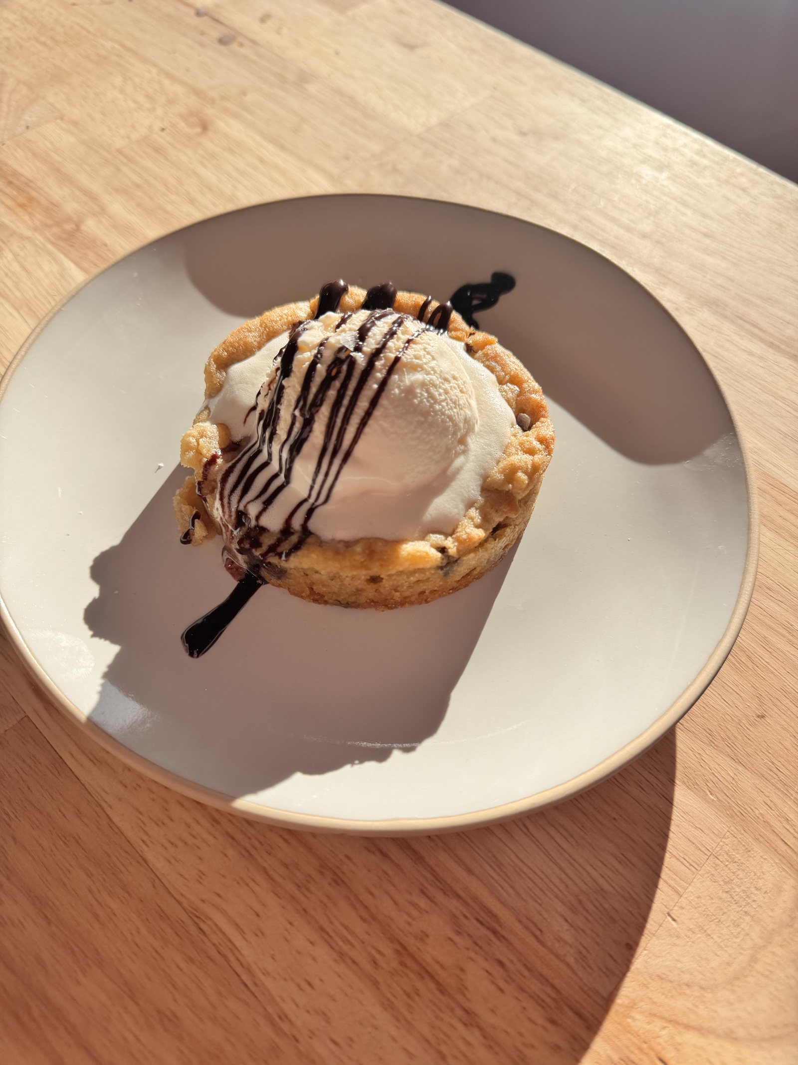 Warm cookie tart with ice cream and chocolate drizzle