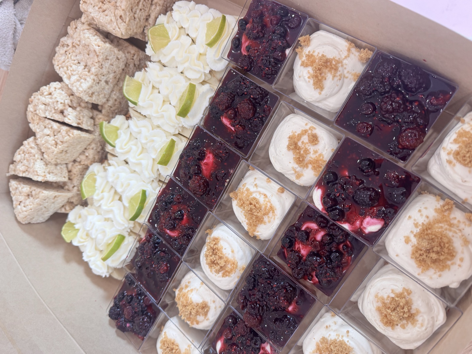 Tray of layered dessert cups with berries and whipped cream