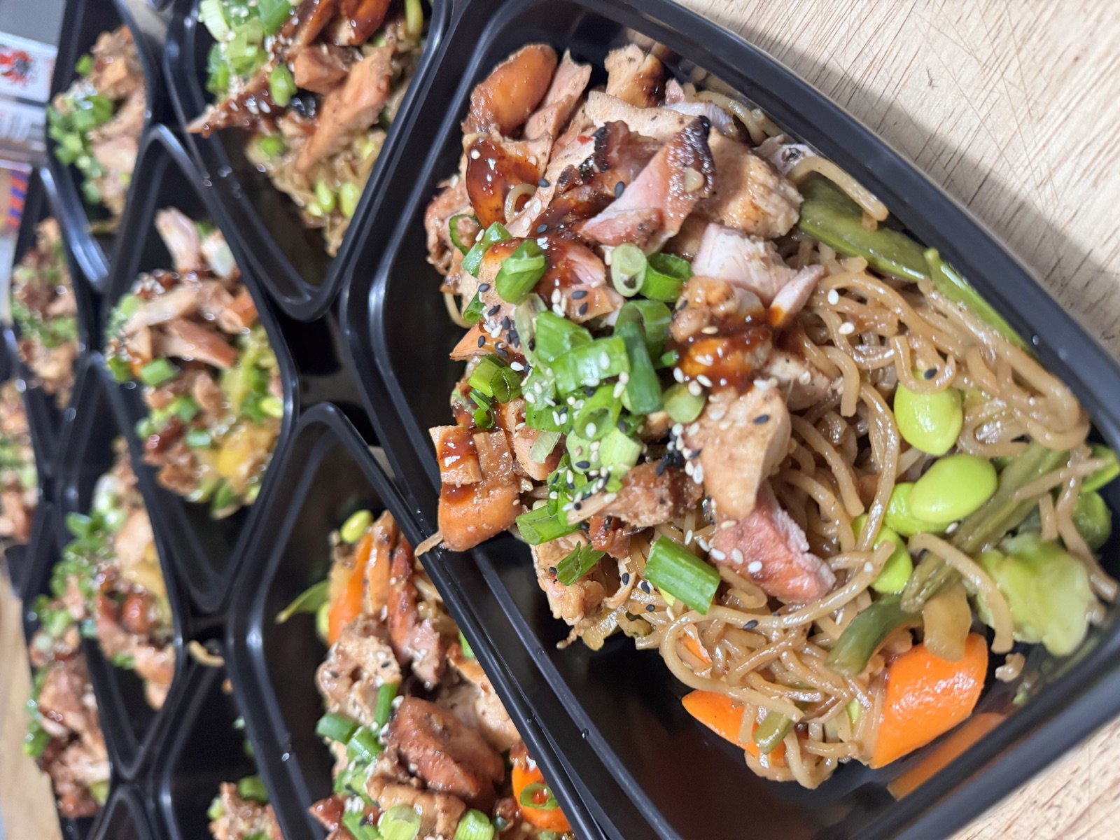 Weekly meal prep boxes with teriyaki chicken and vegetables